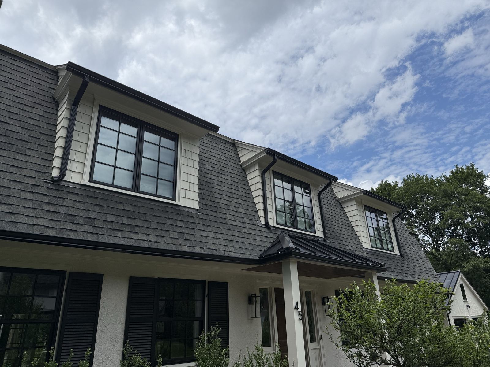 Asphalt shingle roof with dormers, gutters, and soffits on a Greater Boston home