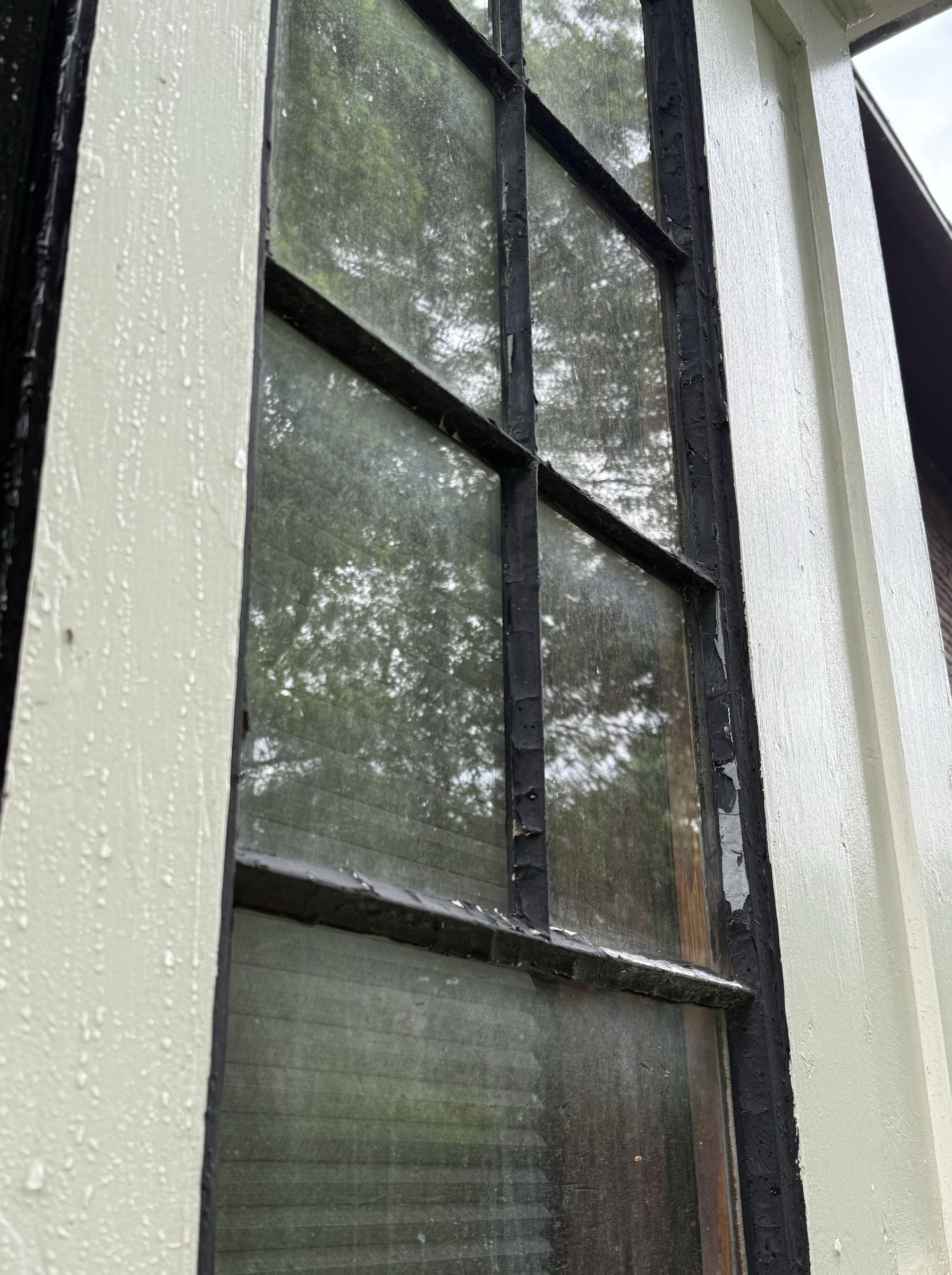 Same diamond-pane window before cleaning — visible water spots and grime